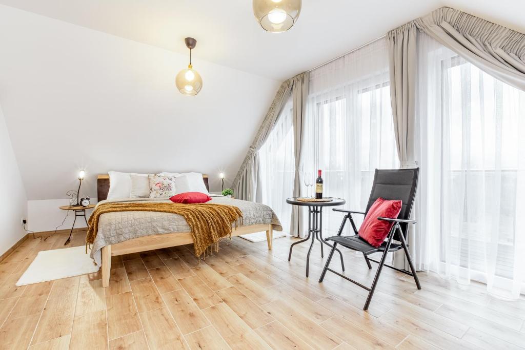 a bedroom with a bed and a table and a chair at Apartmány Karlovy Dvory in Horní Planá