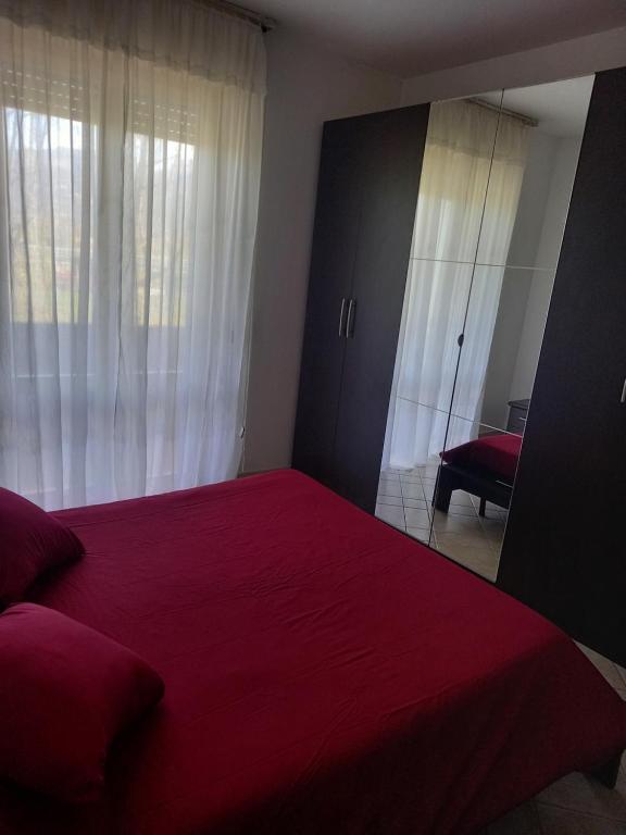 - une chambre avec un lit rouge et un miroir dans l'établissement SUN SEA ReLAX, à Luni