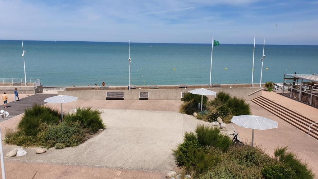 - un parc avec des parasols en face de la plage dans l'établissement Horizon, à Saint-Valery-en-Caux