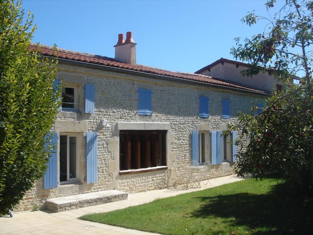 een oud stenen huis met blauwe luiken bij Beautiful renovated farmhouse with private heated pool. in Saint-Pierre-dʼAmilly