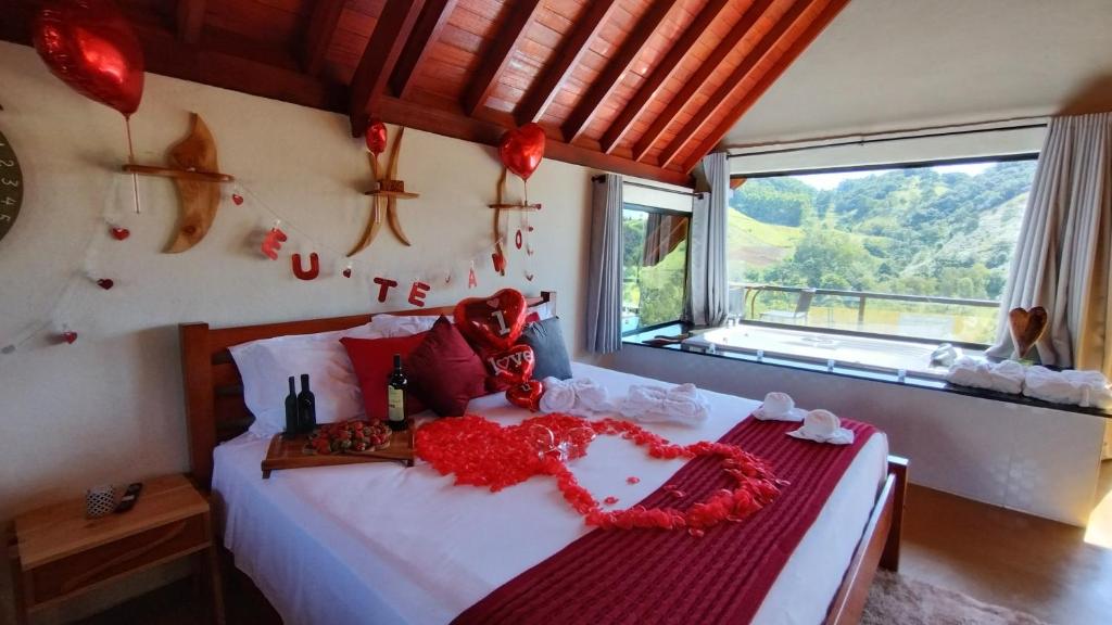 a bedroom with a bed with red flowers on it at Chales Sabor Dos Ventos in Gonçalves