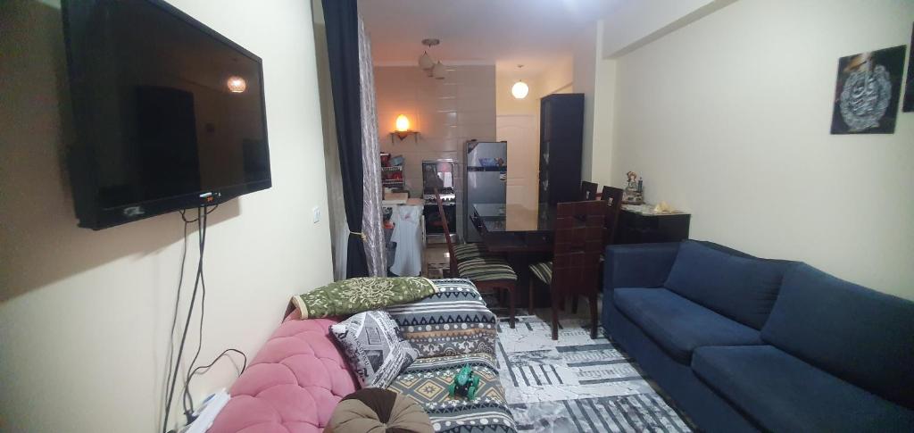 a living room with a couch and a flat screen tv at سيرينا العلمين عائلات ممنوع الجروبات والميكسات in Abū Shunaynah