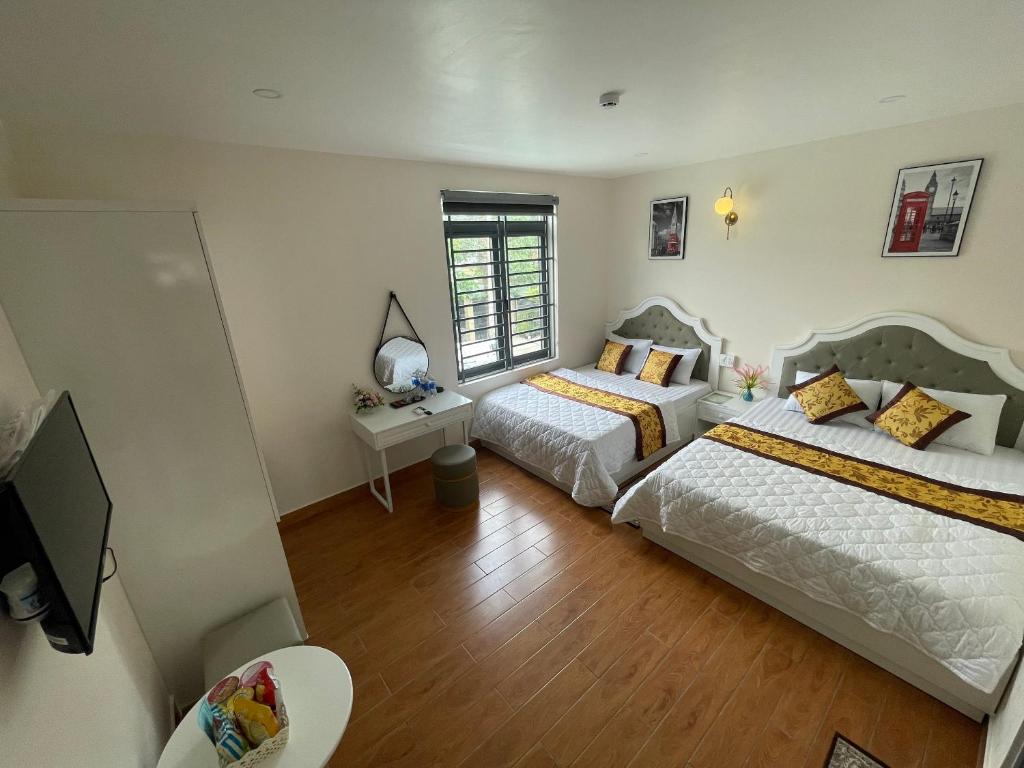 1 dormitorio con 2 camas y TV en Thinh Gia Hotel, en Bến Cát
