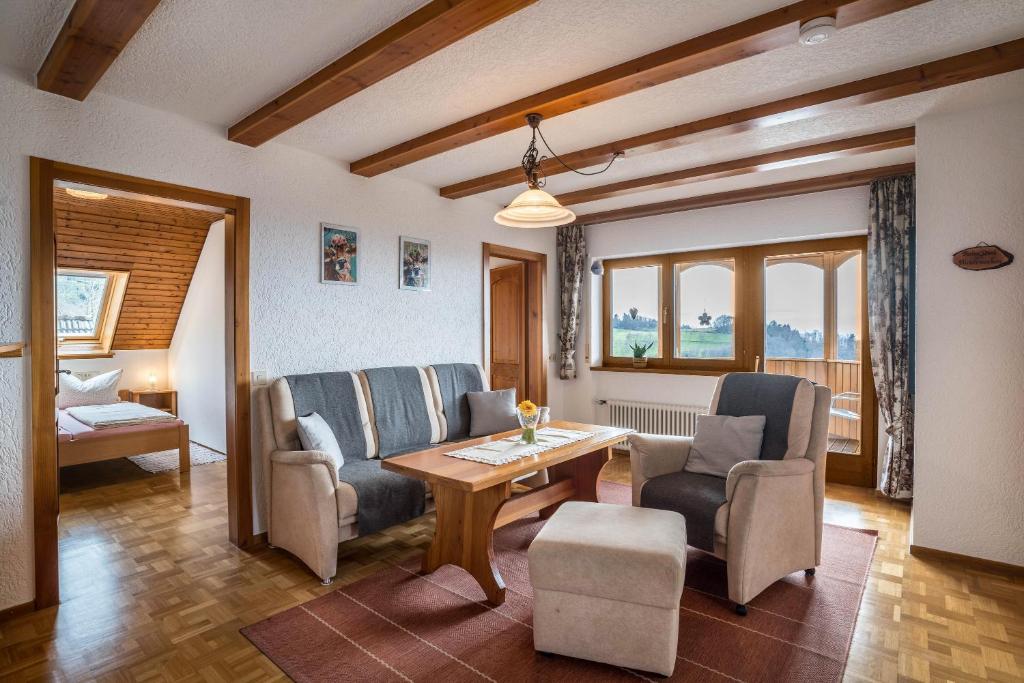 ein Wohnzimmer mit Stühlen und einem Holztisch in der Unterkunft Adlerhorst in Sasbachwalden