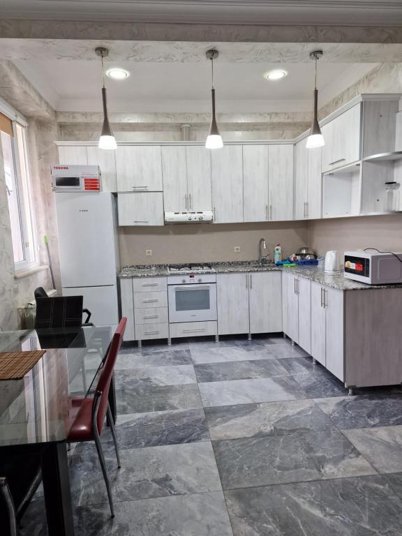 a kitchen with white cabinets and a tile floor at Batumi Flats in Batumi