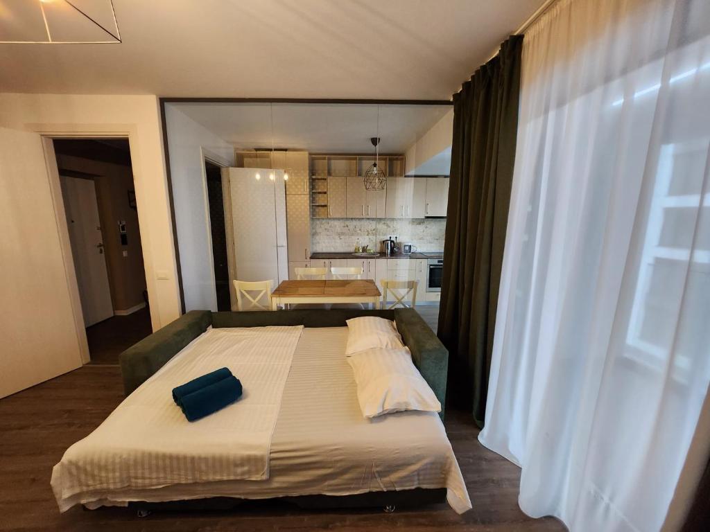 1 dormitorio con 1 cama grande y cocina en Cloud9 Residence Great Apartments, en Bucarest