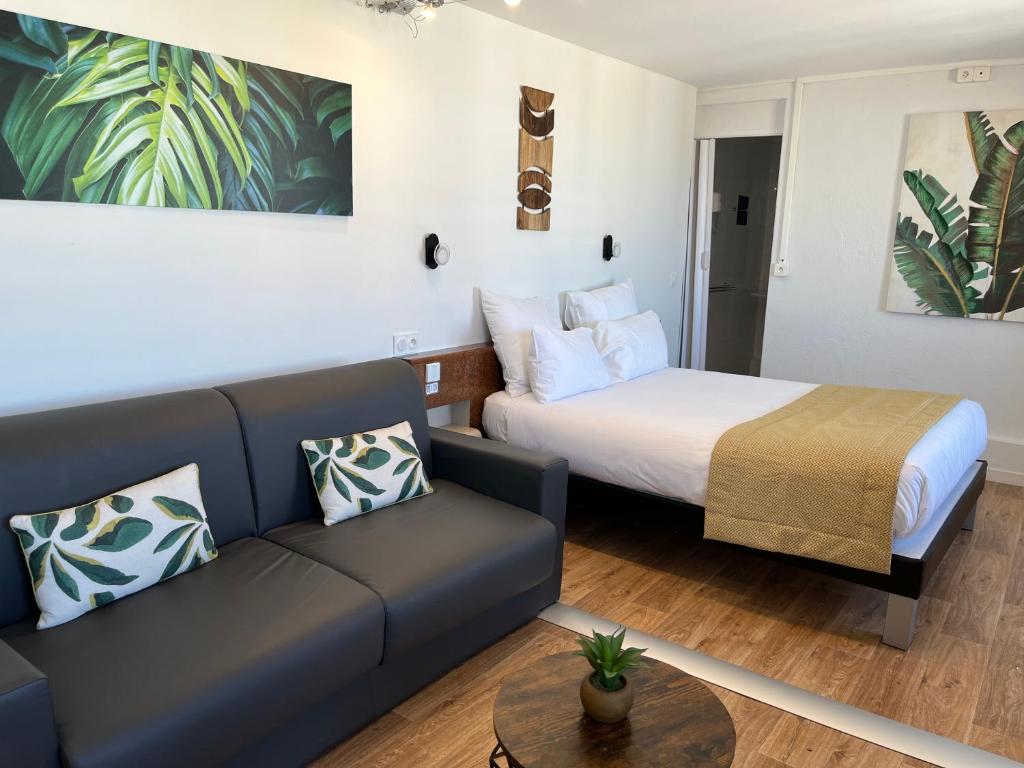 - un salon avec un lit et un canapé dans l'établissement Hôtel Le Mirage, à Saintes-Maries-de-la-Mer