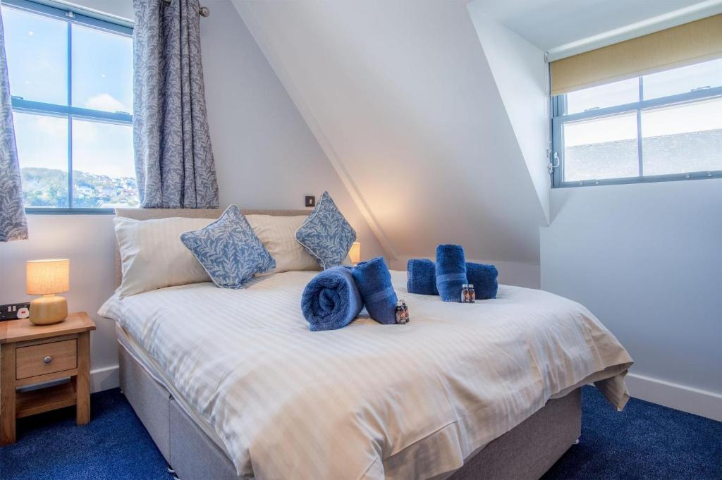 a bedroom with a bed with blue pillows on it at Ocean Cabins No 9 At The Square - Saundersfoot in Saundersfoot