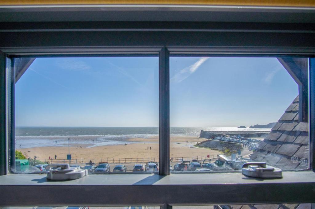 a view of a beach from a window at Ocean Cabins No 14 At The Square - Saundersfoot in Saundersfoot