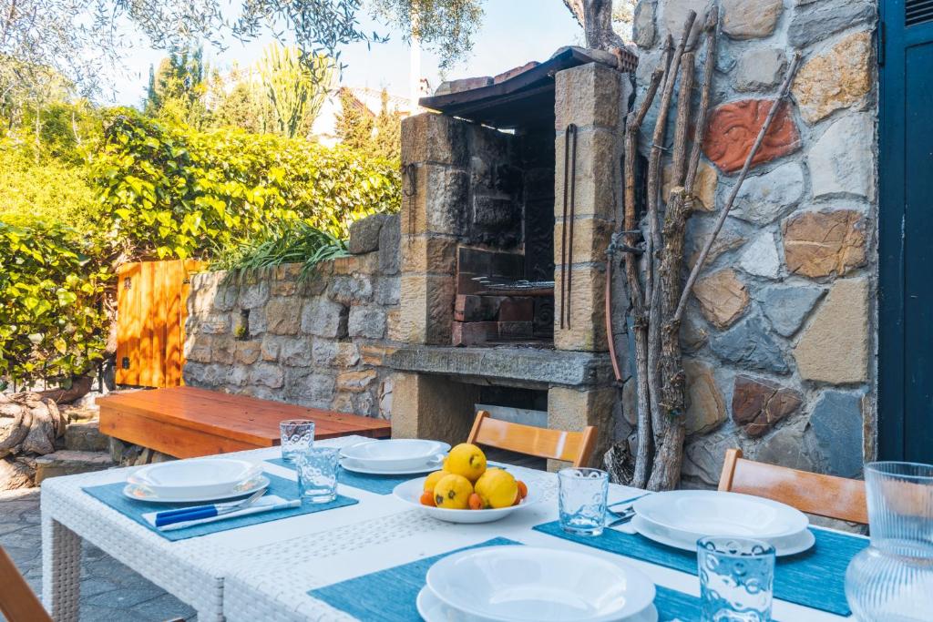 a table with plates and a bowl of fruit on it at Lemon Apartment with Garden and Sea View by Wonderful Italy in Bordighera