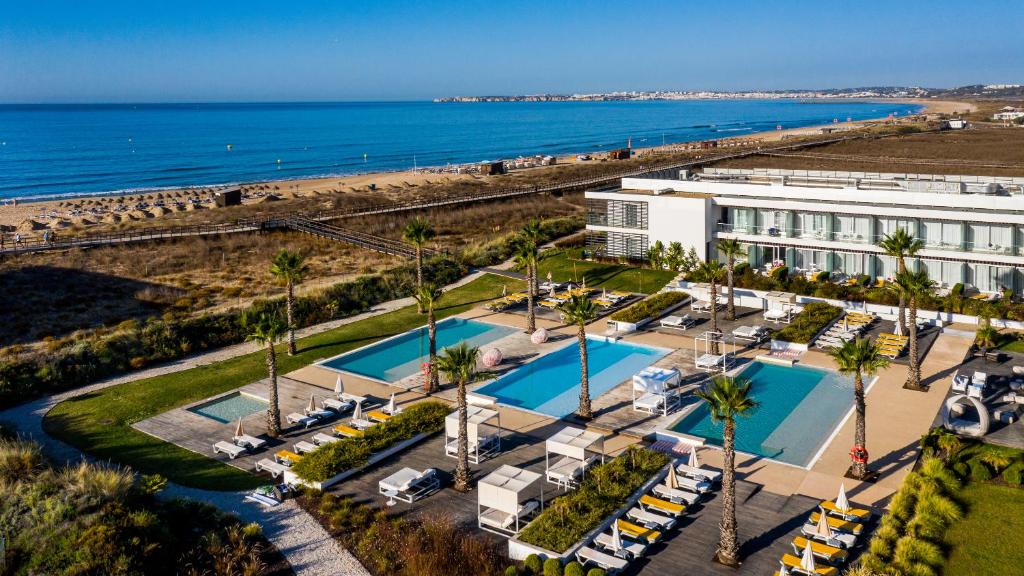 z góry widok na ośrodek z palmami i ocean w obiekcie Pestana Alvor South Beach Premium Suite Hotel w Alvor