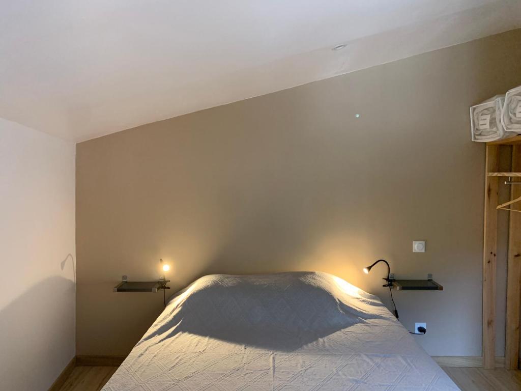 a bedroom with a bed with two lights on the wall at gîte du Cady in Casteil