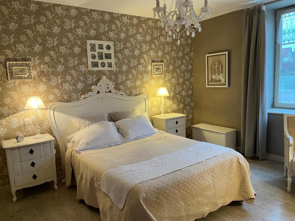 - une chambre avec un lit et 2 tables de nuit avec des lampes dans l'établissement Chez Elodie, à Pressigny