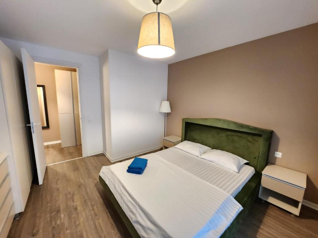 Un dormitorio con una cama con un libro azul. en Pipera Cloud9 Apartments near Promenada Mall, en Bucarest