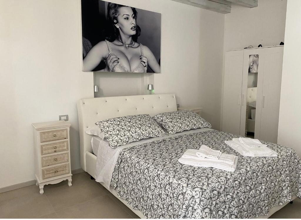a bedroom with a bed and a picture of a woman at Cinema Rooms Fiera Verona in Verona
