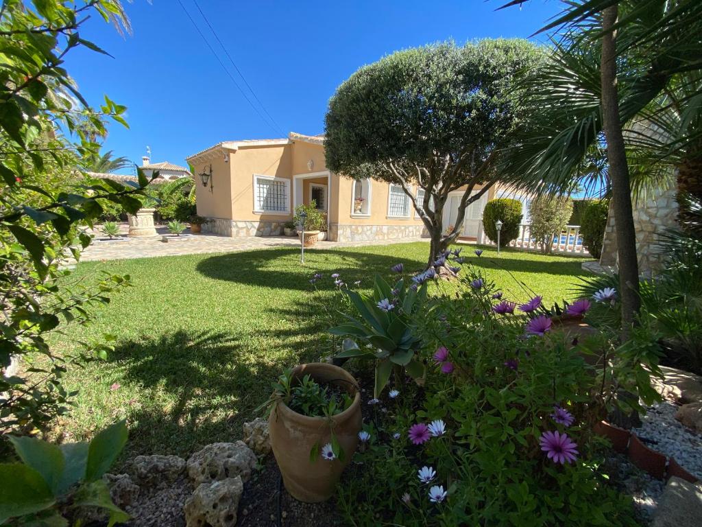 a house with a garden with flowers in the yard at Casa Nieves Cabo roig in Orihuela