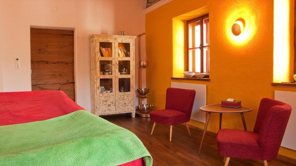 1 dormitorio con 1 cama, 2 sillas y mesa en Tauglerei Appartement Kamin in den Zauberbergen, en Sankt Koloman