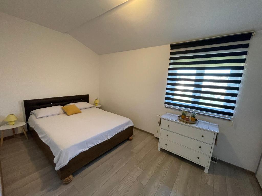 um pequeno quarto com uma cama e uma janela em Apartmani Anida em Porec