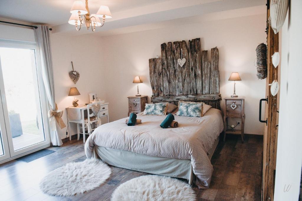 a bedroom with a large bed with a wooden headboard at Au charme d'antan in Féron