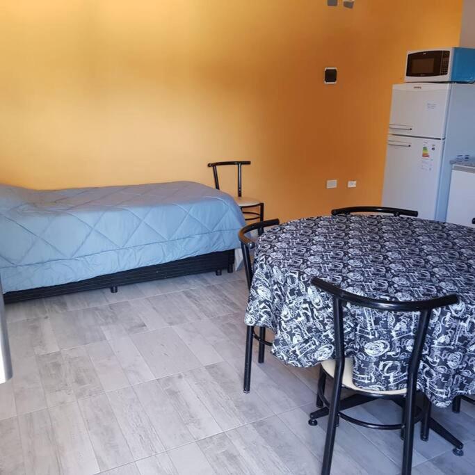 a room with a bed and a table and chairs at San Luis zona Shopping/ centro in San Luis