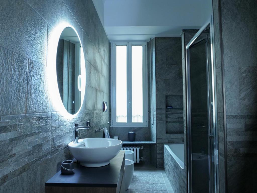 ein Bad mit einem Waschbecken und einem Spiegel in der Unterkunft Wonderful downtown apartment-HD NETFLIX, KING-SIZE BED, two minutes' walk from metro in Mailand