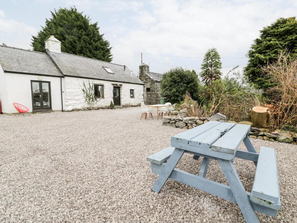 a blue picnic table in front of a cottage at 2 Pant Heulog in Dyffryn