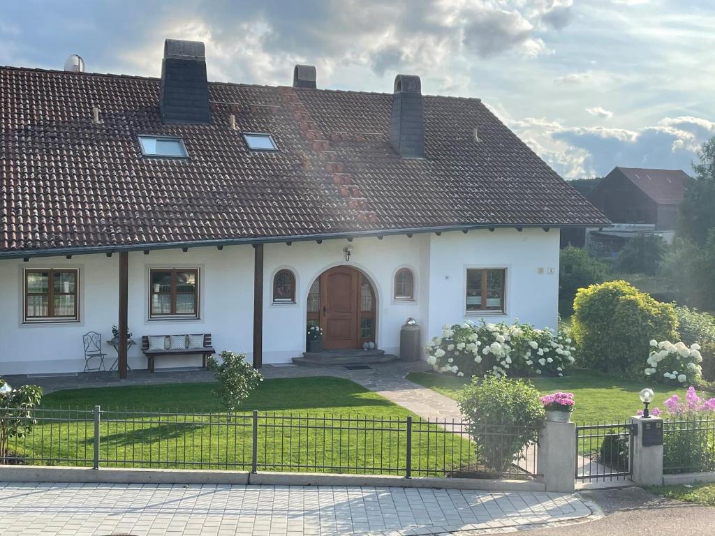 ein weißes Haus mit braunem Dach in der Unterkunft Ferienwohnung Leixenring in Riedenburg