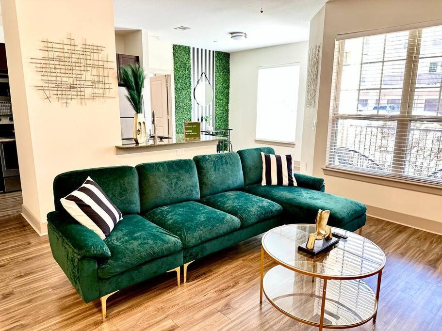 een groene bank in een woonkamer met een tafel bij Emerald City Luxury Suite ~Fully Gated Community in Midland