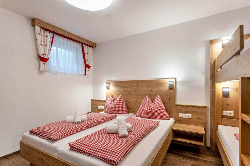 Schlafzimmer mit einem Bett mit roten und weißen Kissen in der Unterkunft Apartment mit Blick auf die Berge in Rettenstein