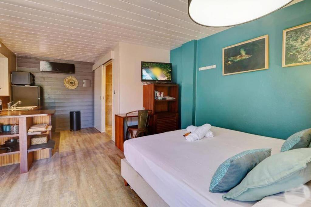 Schlafzimmer mit einem Bett, einem Schreibtisch und einem TV in der Unterkunft Studio T1 - Cosy Pêcheur in Saint-Leu