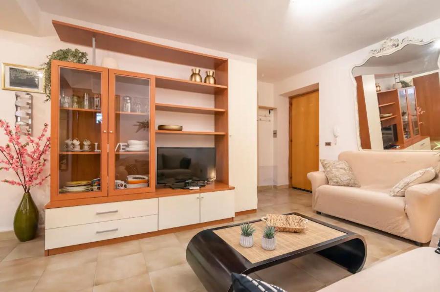 ein Wohnzimmer mit einem Sofa und einem TV in der Unterkunft Trilocale a 150 metri Spiaggia Alghero in Alghero