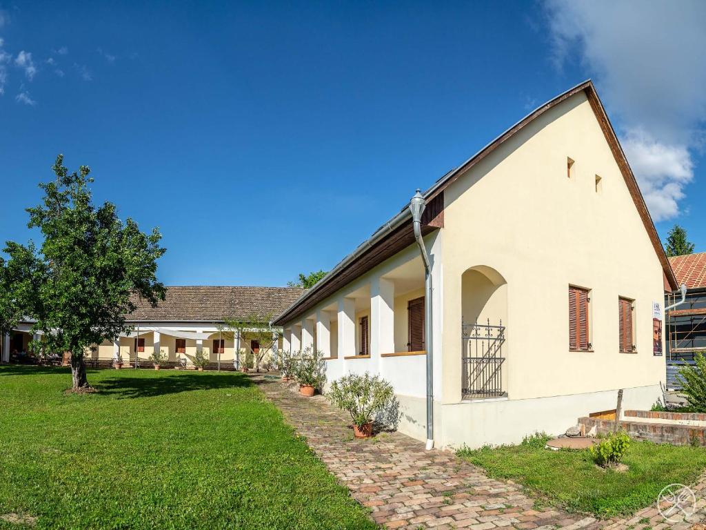 a large white building with a grass yard at Jackfall Apartman és Fogadó in Kisjakabfalva