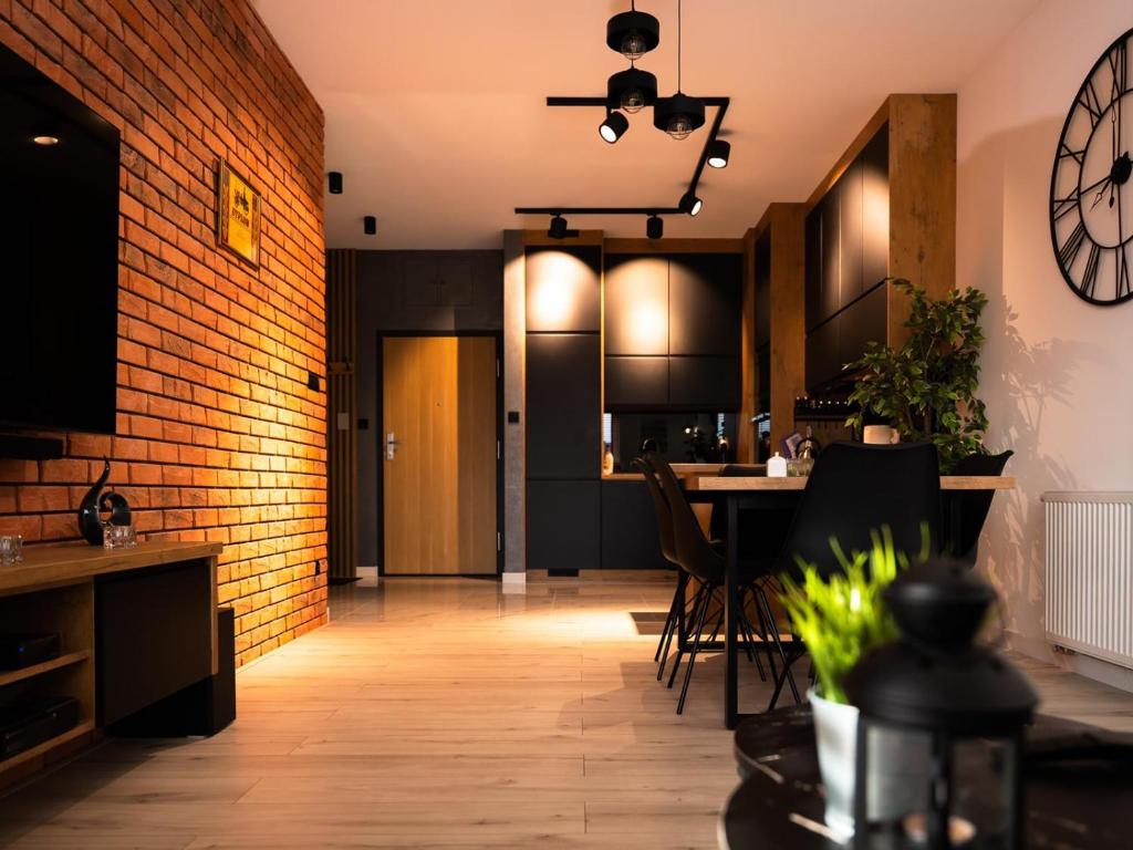 a kitchen and dining room with a brick wall at Apartament Uniejów in Uniejow