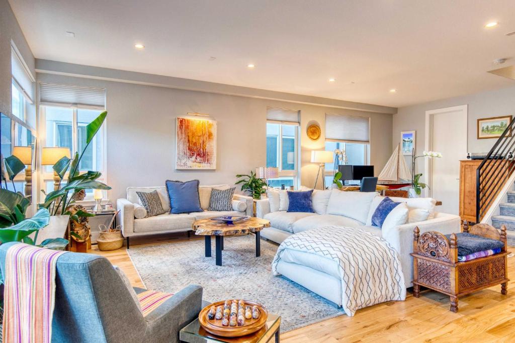 ein Wohnzimmer mit weißen Möbeln und blauen Kissen in der Unterkunft Walk to Empower Field Townhome with Hot Tub! in Denver