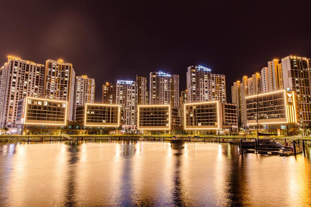 um horizonte da cidade à noite com um corpo de água em Ocean Marina Suite View em Yeosu