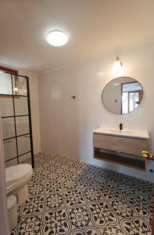 uma casa de banho com um WC, um lavatório e um espelho. em Casa Arrayán em Santiago