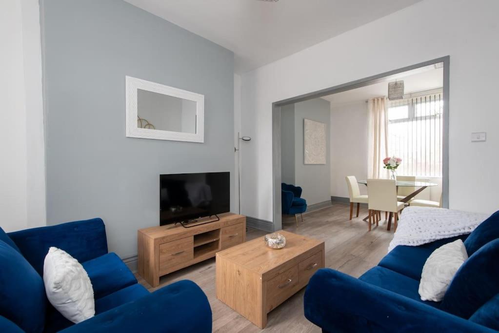 a living room with a blue couch and a tv at 25 Station in Ushaw Moor