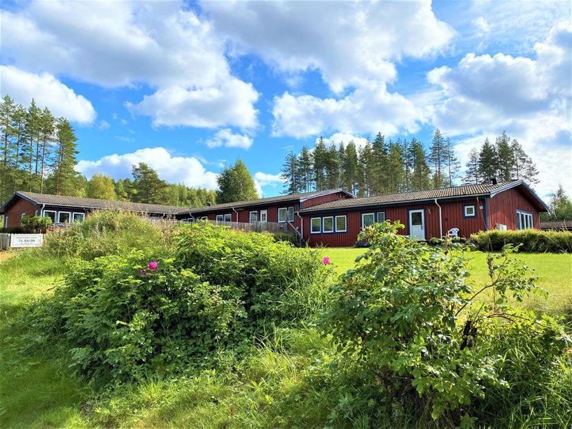 un grand bâtiment rouge dans un champ d'herbe dans l'établissement Långrösta 48-49, Appartementen in Hagfors, à Hagfors