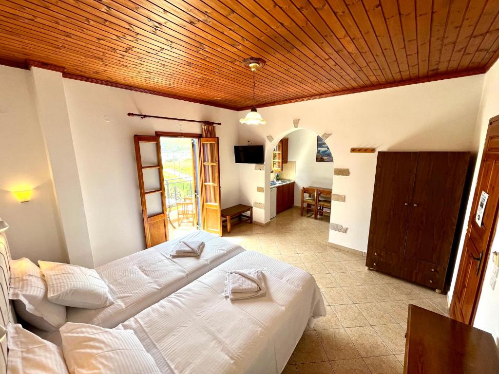 a bedroom with two beds and a living room at Nicolas Studios in Skala