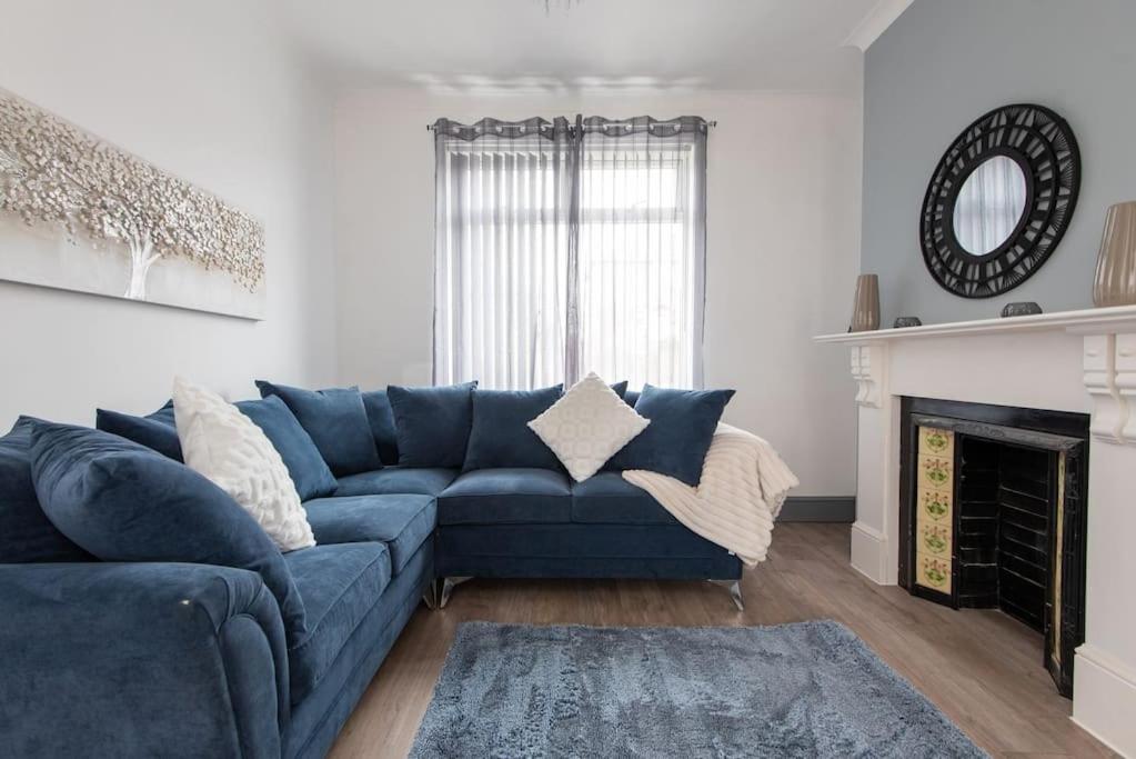 a blue couch in a living room with a fireplace at 26 Station in Ushaw Moor