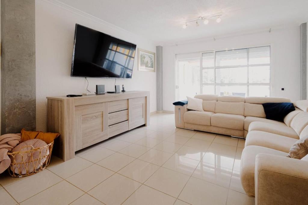 a living room with a couch and a flat screen tv at Adosado en Costa Adeje in Playa de las Americas