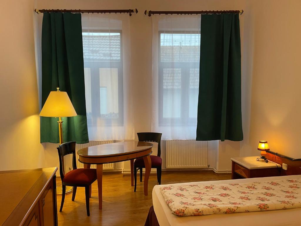 Cette chambre comprend une table, un lit, une table et des chaises. dans l'établissement Pensiunea Mimi, à Mediaş