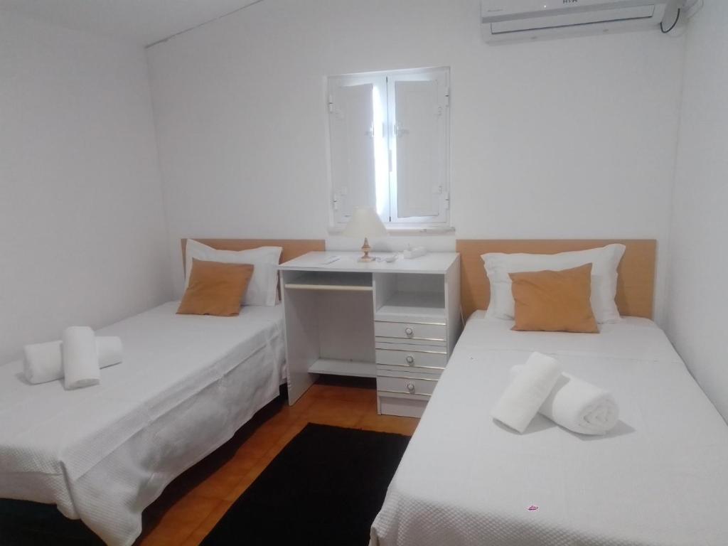 2 camas individuais num quarto com um lavatório em Casas da Saibreira - nº2 em Elvas