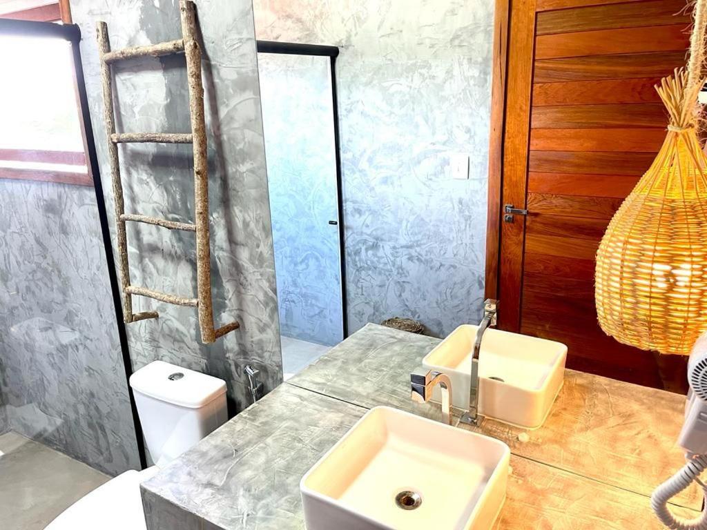 a bathroom with a sink and a toilet at Pousada Ybitu in São Miguel do Gostoso