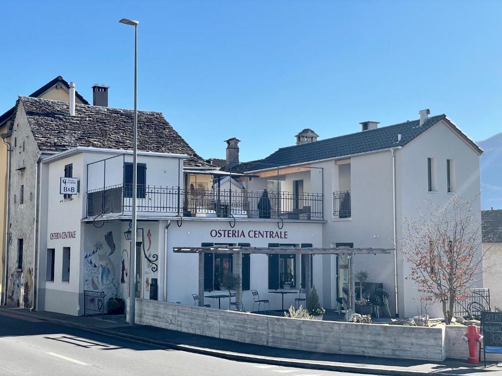 un edificio blanco en la esquina de una calle en Osteria Centrale - B&B, en Cugnasco