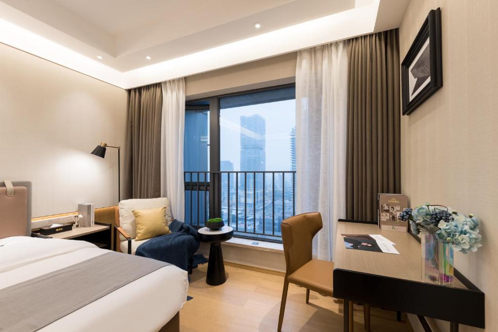 Habitación de hotel con cama, escritorio y ventana en Livetour Hotel International Financial City Guangzhou, en Guangzhou
