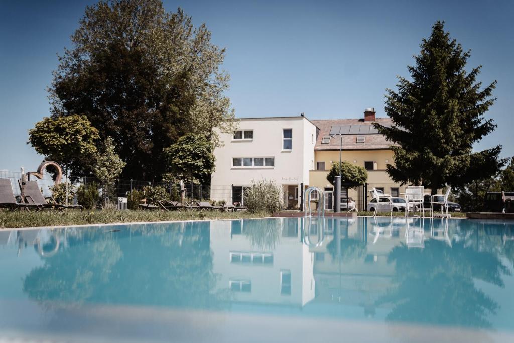 a large pool of water in front of a house at Gasthof Martinhof in Sankt Martin im Sulmtal