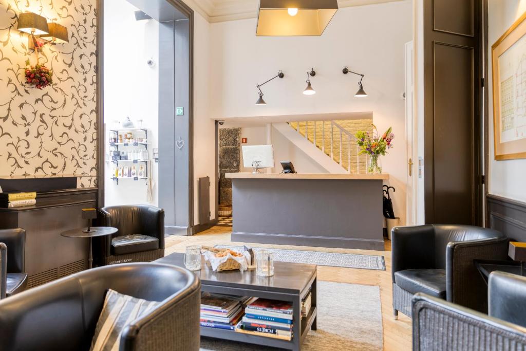 a lobby of a restaurant with chairs and a table at Hotel Made In Louise in Brussels