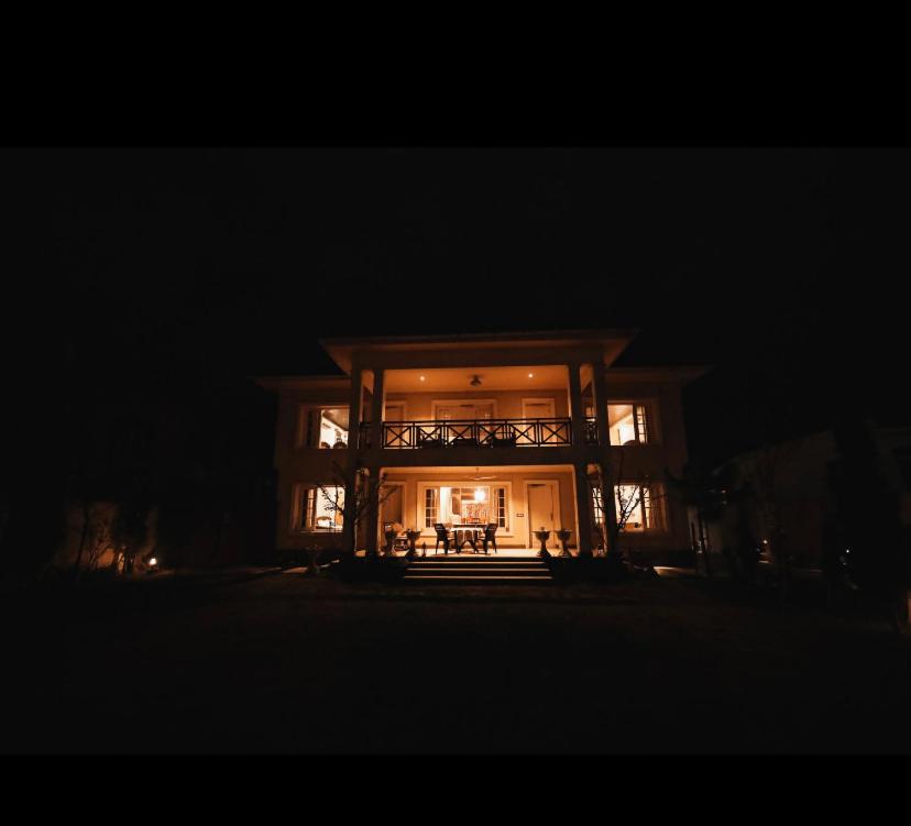 duży dom w nocy z włączonymi światłami w obiekcie The Kingsland7 w mieście Śrinagar