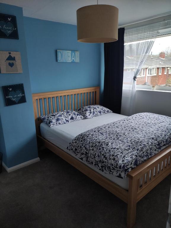 un letto in una camera da letto con parete blu di 3 bed house in Walsall, perfect for contractors & leisure & free parking a Walsall